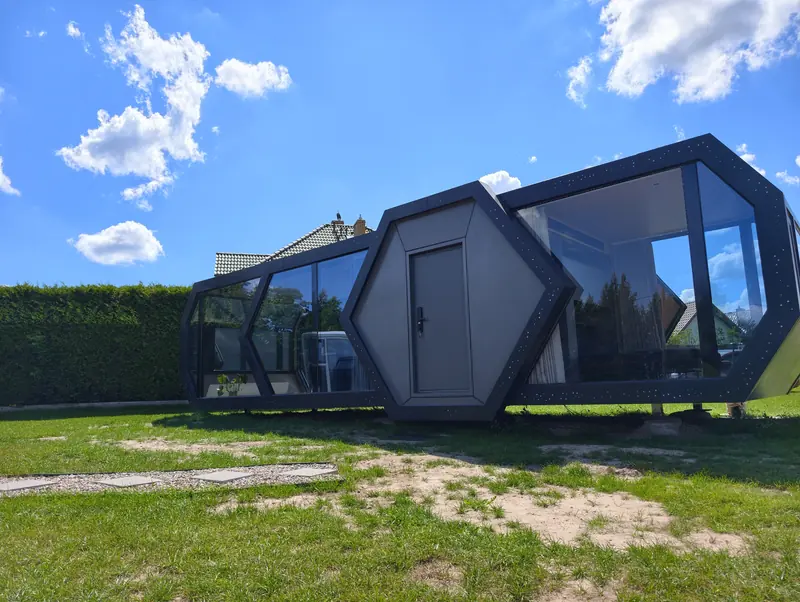 Grafitowy dom kapsułowy o geometrycznej bryle na działce