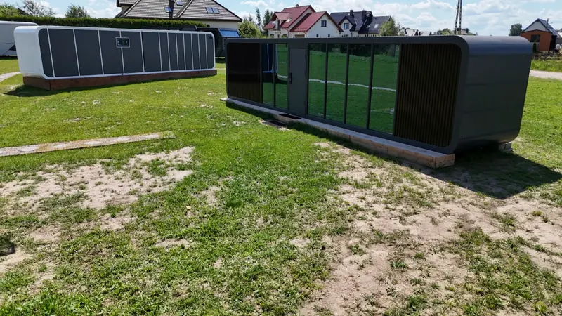 Dwa domy kapsułowe ustawione na działce